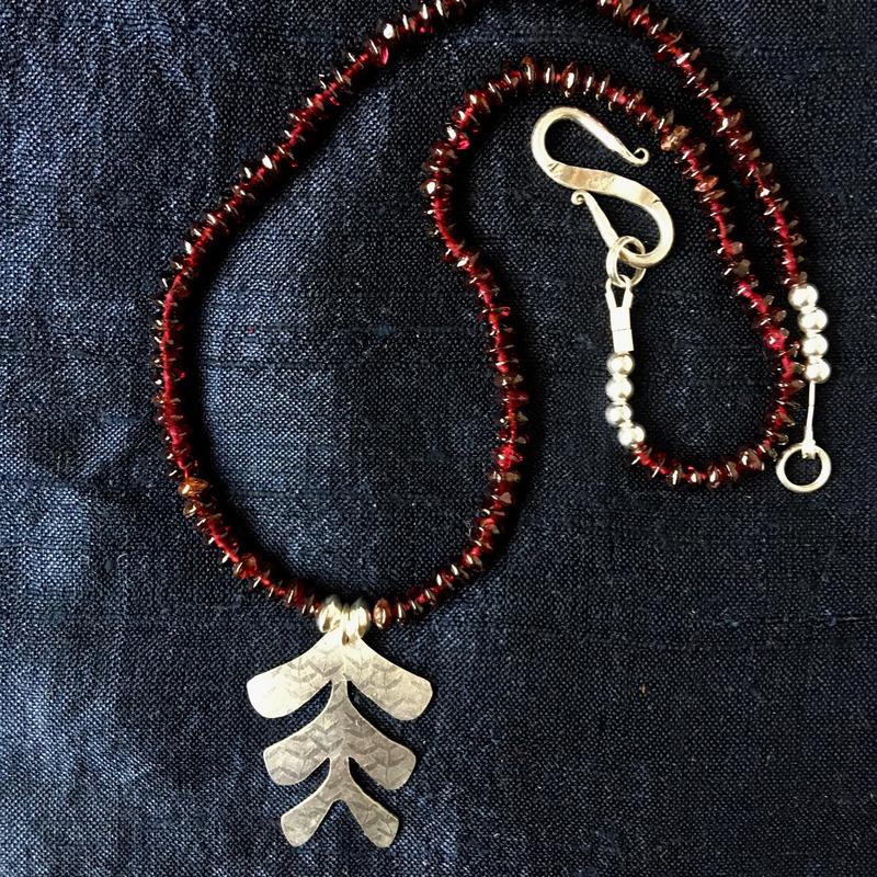 Hand-cut textured silver pendant with garnets and silver beads