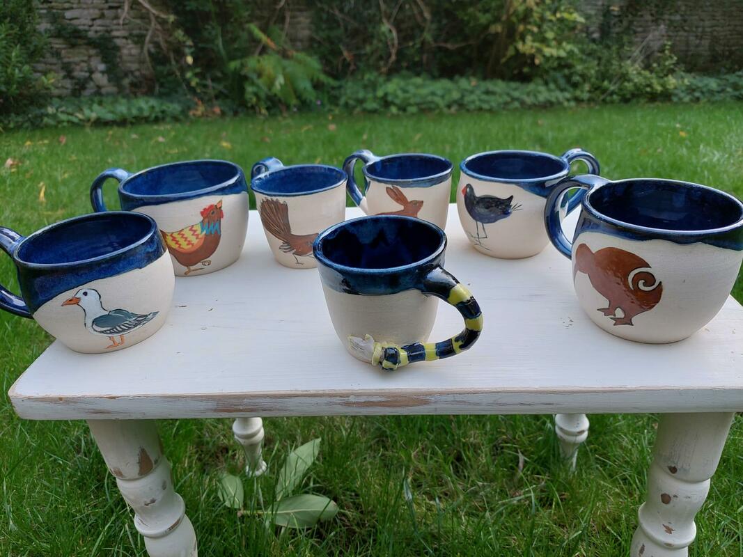 Hand-painted mugs in blue glaze & one with a hand-le.