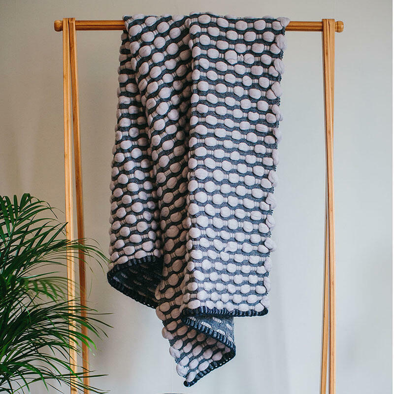 Handwoven 'Ripples' throw featuring soft wool roving in light blue with a navy woven background