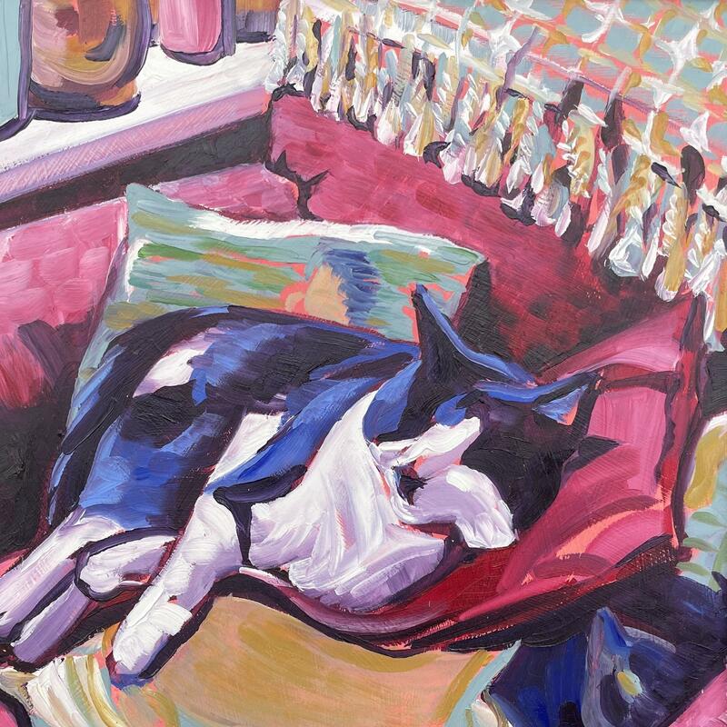 Painting of a black and white cat asleep on a red armchair full of scatter cushions