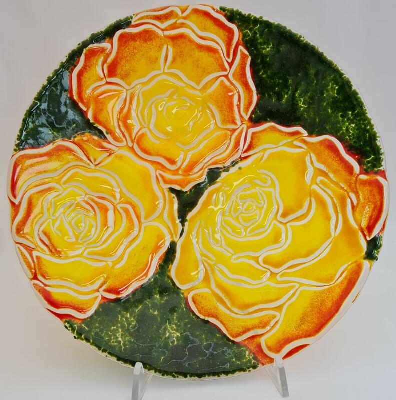 Large glass bowl with orange, yellow and red roses