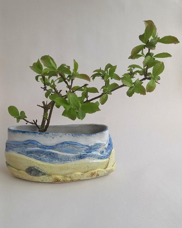 Ceramic vase decorated with an abstract coastal scene represented in colour and texture