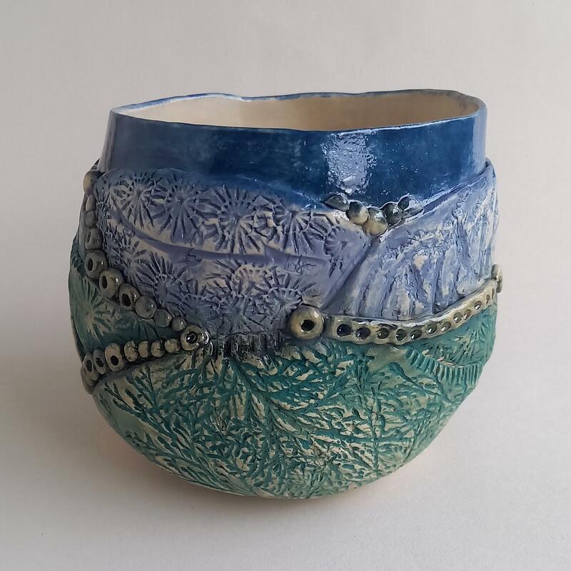 Ceramic vase decorated with an abstract landscape with colours suggesting early evening and textures for hedgerows and land