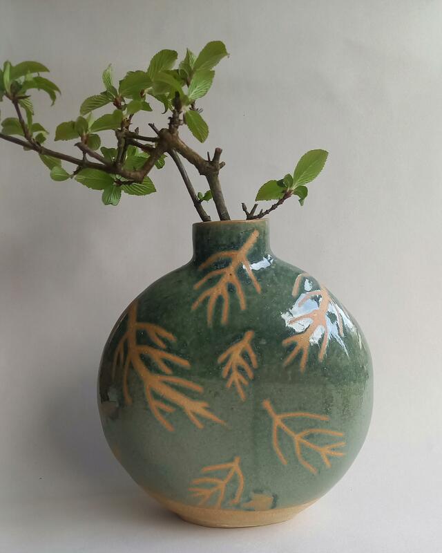 Ceramic bottle shaped vase in pale green with a simple graphic fern leaf motif 