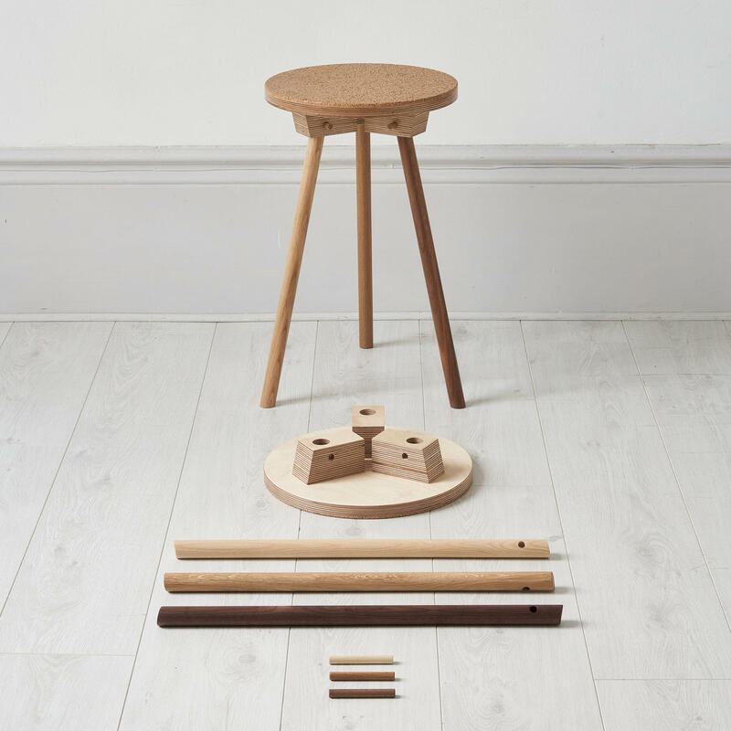 Pegg Stool, with cork faced top and ash, oak and walnut legs: shown built with the components that make it up on the floor in front of it.