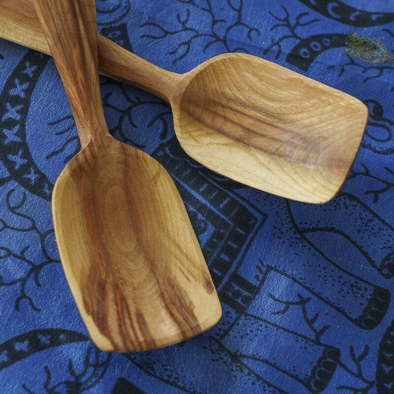 The bowls of two hand-carved wooden spoons, from the same branch, in cherry wood, by Michael J. Amphlett