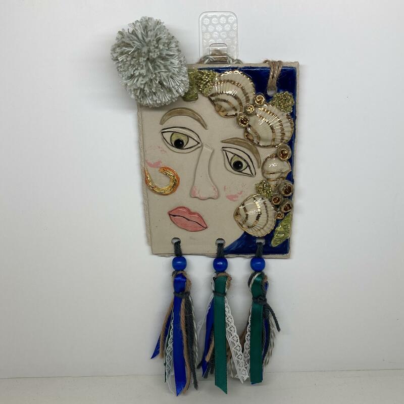 Venus. A series of ceramic and mixed media, postcard sized interpretations, of well known faces. This depiction is of the Birth of Venus.  It is a 11.5x15cm stoneware tile adorned with real gold lustre and kiln fired 3 times. Venus has a handmade pompom and tassels of ribbon, lace and wool. Total size is 11.5x30cm.