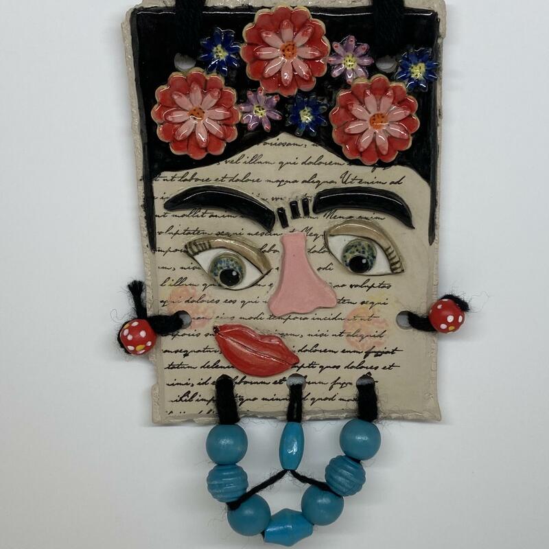 Frida. A series of ceramic and mixed media, postcard sized interpretations of well known faces. This depiction is of Frida Kahlo. This is a stoneware tile 11x16cm decorated with coloured wooden beads. Total size is 13x21cm.