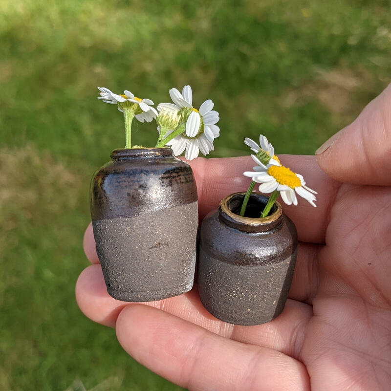 hand holding two mini vase