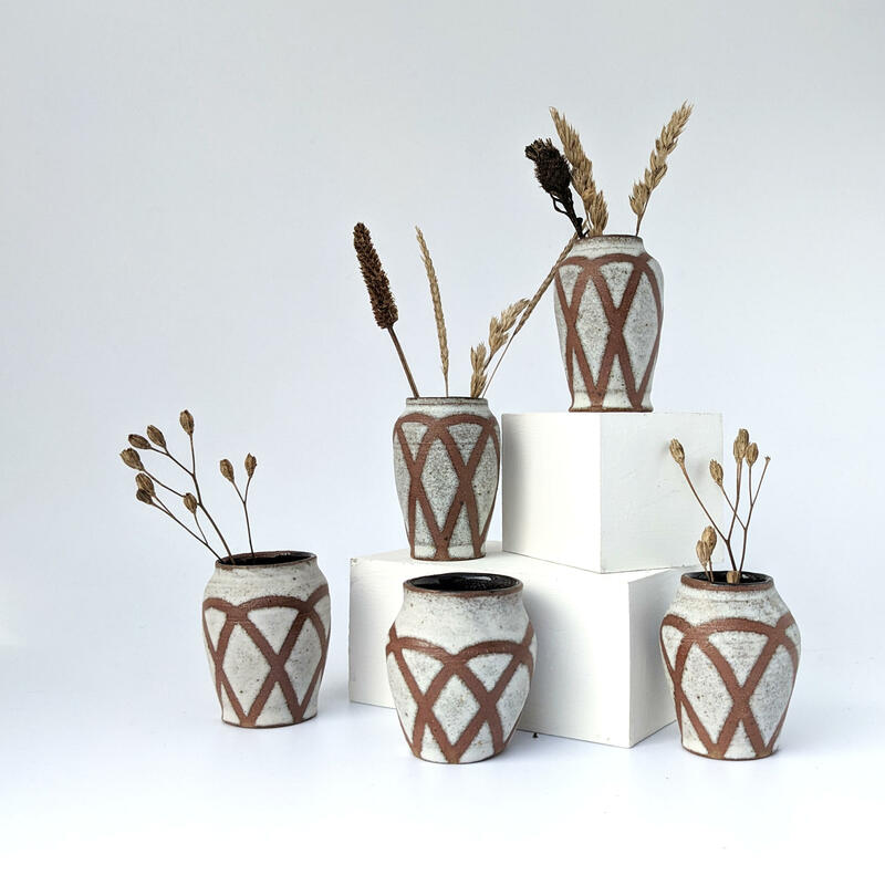 Set of mini vases holding dried grasses 
