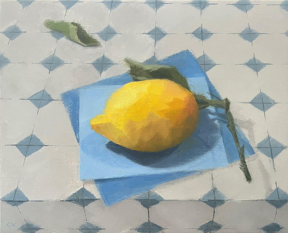 Lemon, an oil painting by Claire Venables is a bright positive painting showing a bright yellow lemon. The lemon contrasts with the blue paper it is sitting on. A leaf fallen from the lemon's stem has landed on the blue and white kitchen tiles that gives a sense of depth.