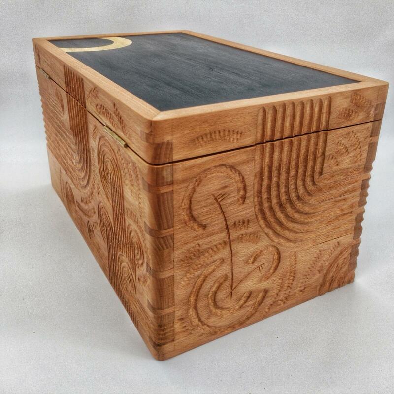 Rounded dovetailed box. Hand carved detail and marquetry panel. 