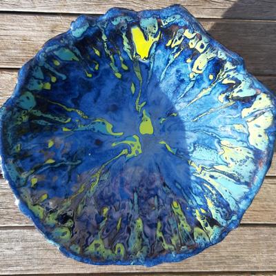 large handmade coiled dish with tripod feet and colourful blue and yellow glaze