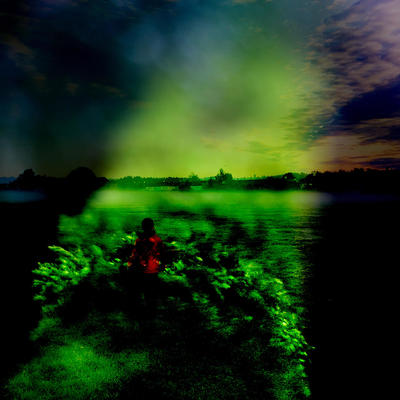 Indistinct image with darkened edges and green field with child in red coat looking towards distant houses