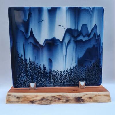 Fused art glass panel in a blue and white chinese design on a yew wood stand.