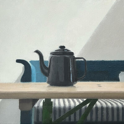 Fuelled by Tea is an oi painting by Claire Venables. A black enamel teapot stand on a table. A shaft of shadow from an unseen skylight is cast diagonally across the scene.