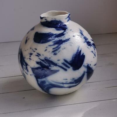 white spherical pot with blue brush strokes