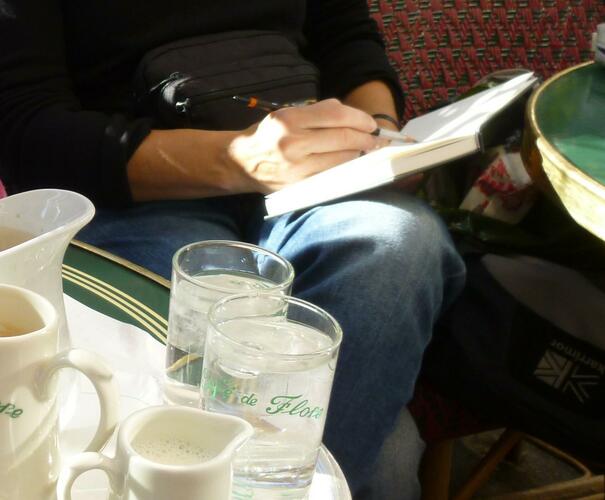 The artist sketching in a French cafe