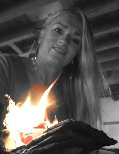 Alison Vincent making glass with a flame in her hand