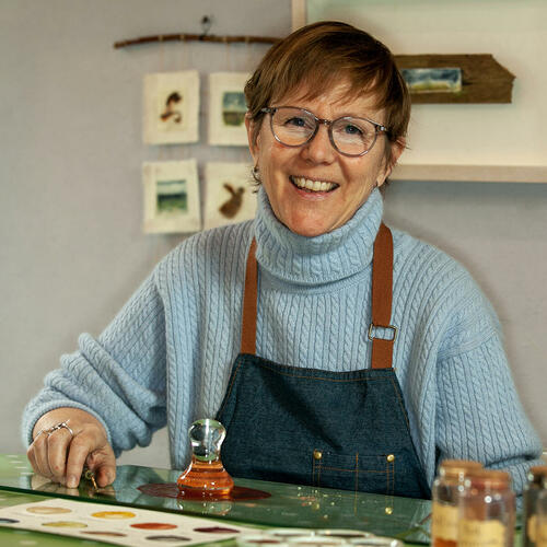 Carol Harvey in her studio mixing natural watercolour paints