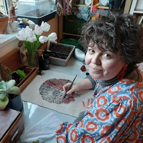 Molly working at her desk on a leaf print/ drawing 