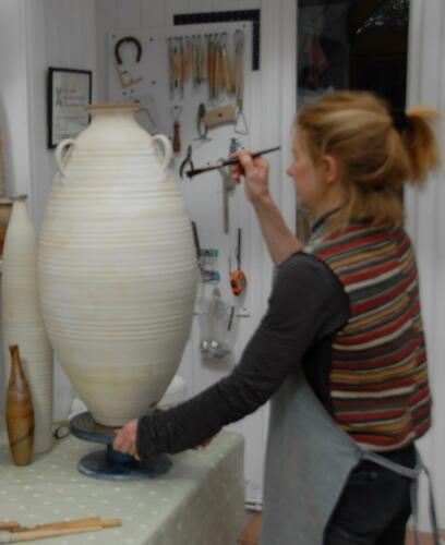 Decorating a tall jar with slip before an anagama firing