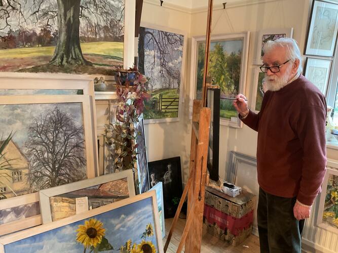 Neville Crowson painting in his studio