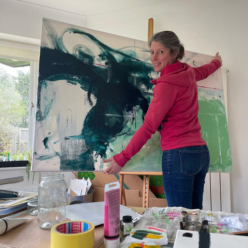 Nikki in her studio with a large abstract painting