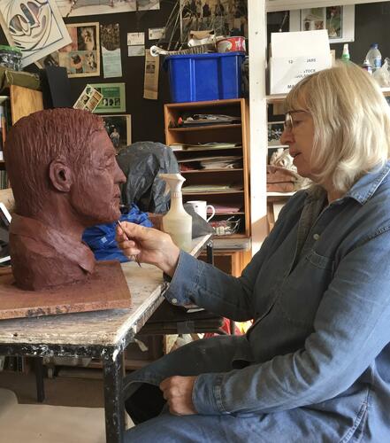 Sally working on a portrait head of George Clooney
