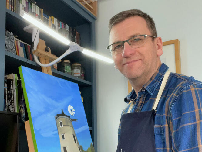 Tim Kapp standing at his easel, paintbrush in hand