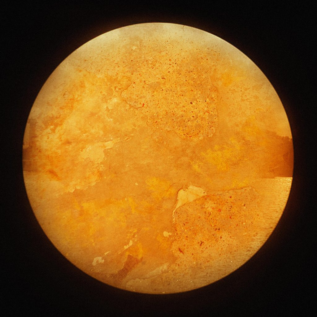 abstract image of golden yellow textured circle, an image of the floor of Magdalen Road Studios. Photograph by Tom Andrew