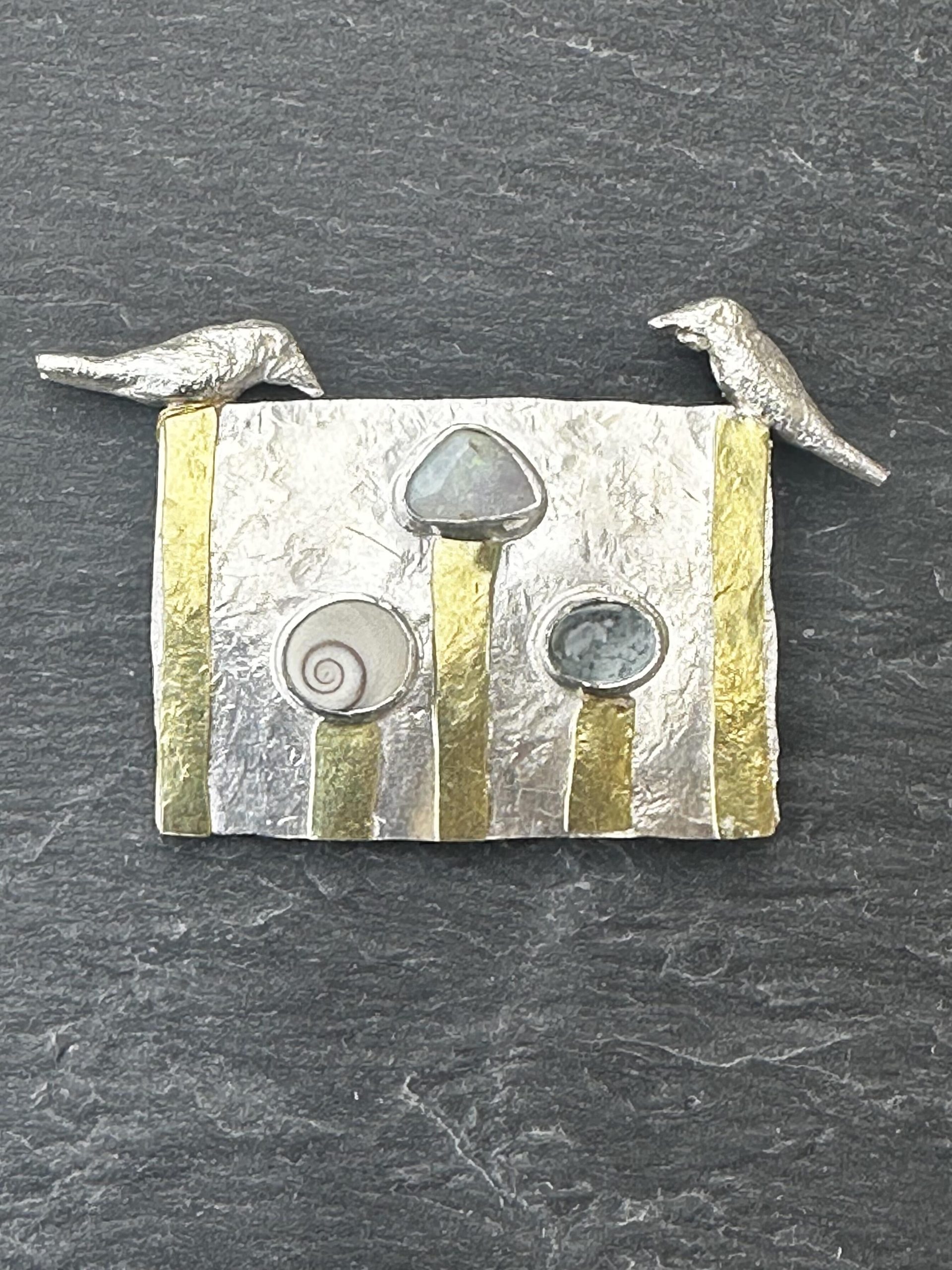 Tony Thomson: Tony Thomson Brooch: Two silver birds, operculum, opal, aquamarine with 18ct yellow gold decoration