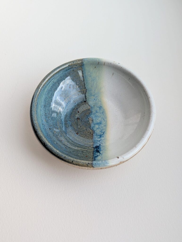 Wheel thrown stoneware ceramic bowl with jade blue and white glaze over flecked clay