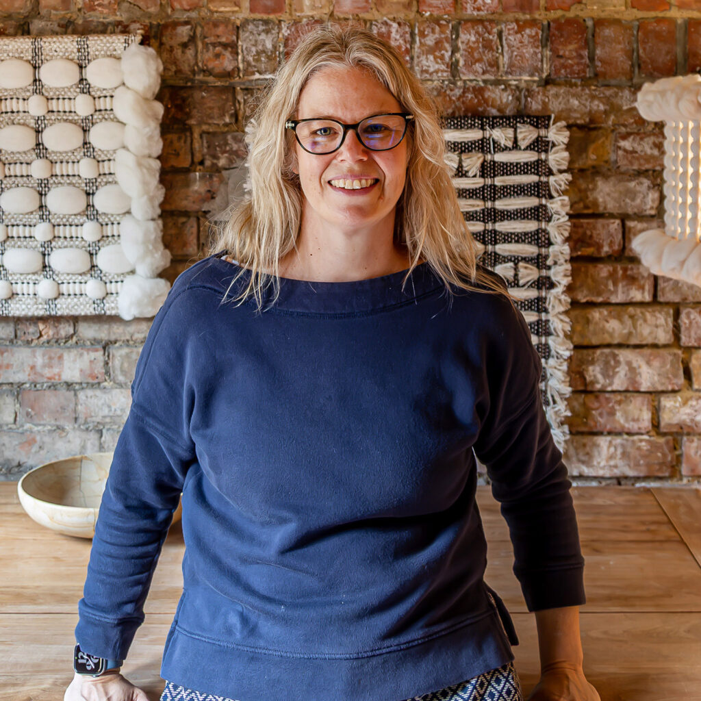 Cassandra Sabo standing in front of her new acoustic panels and lampshades in her Oxford studio..