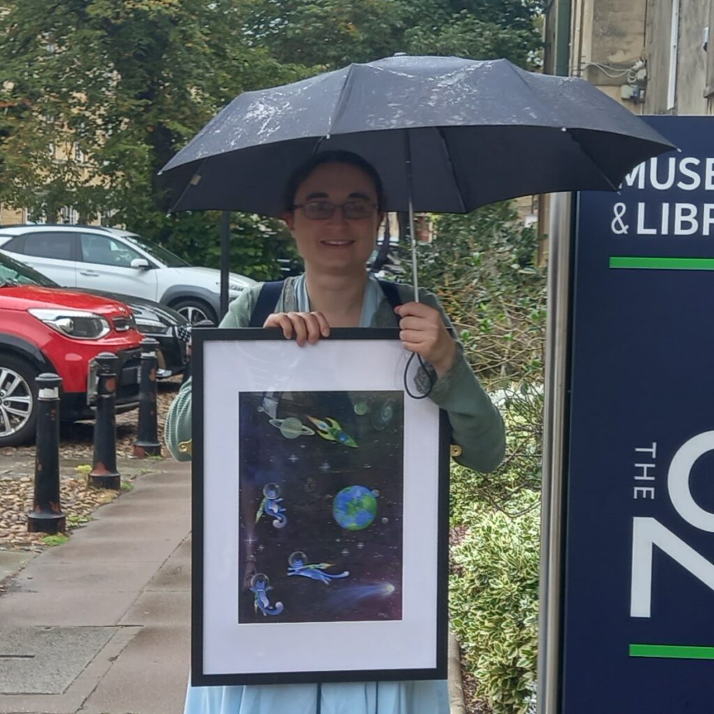 Ruth Harris holding her artwork 