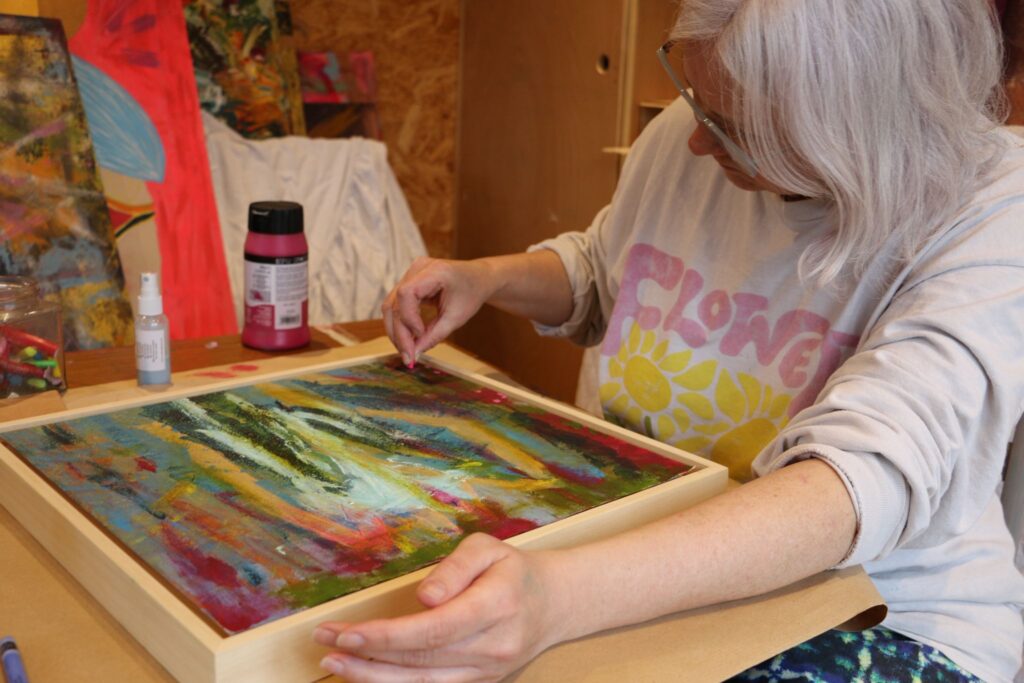Artist at work - Oxford abstract colourist artist adding final touches with oil pastels.