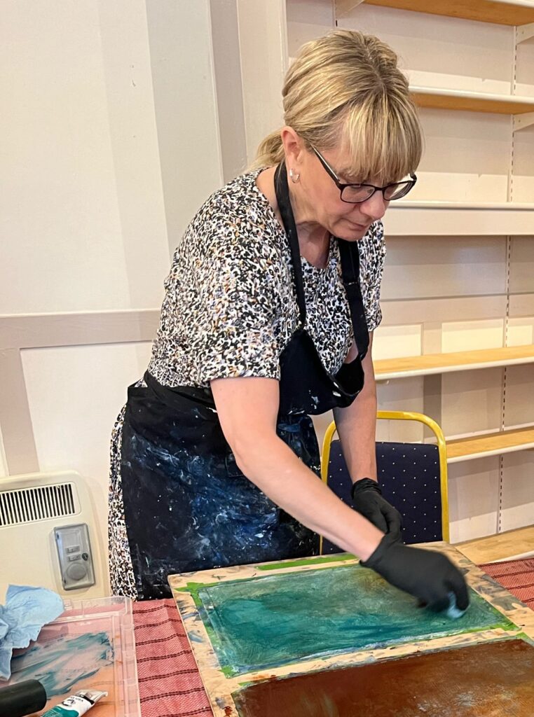 The artist working on an oil and cold wax painting