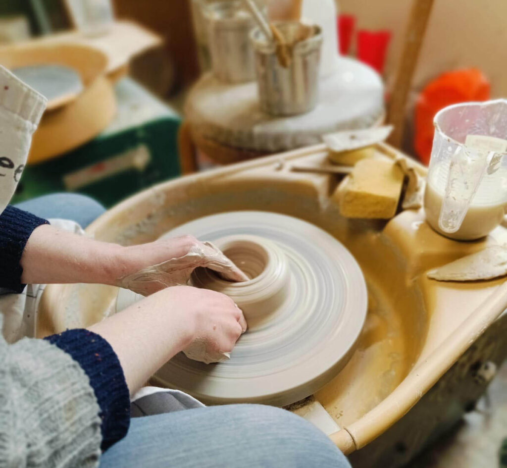 Laura Murphy making a vessel on the pottery wheel