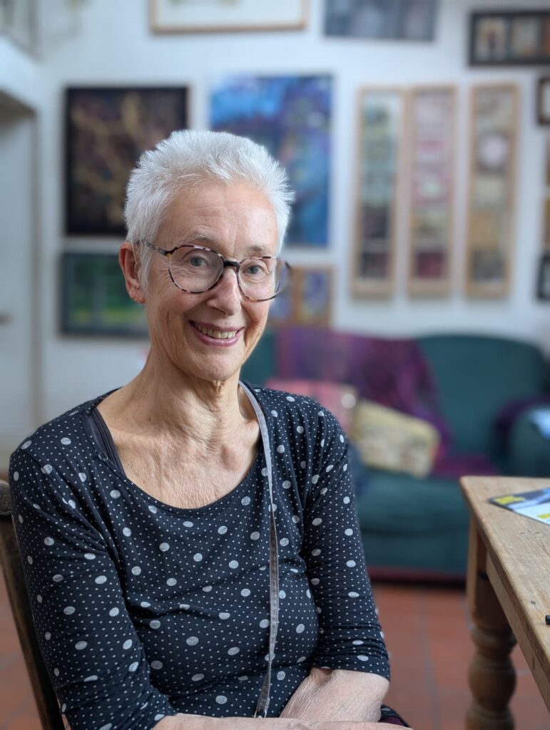 Judy Hammond and her artworks in the background