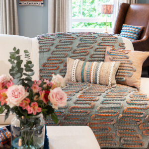 Cassandra Smith: Handwoven throw and cushion displayed in a living room with a soft colour palette