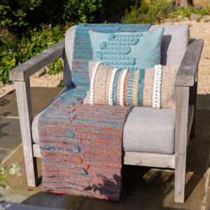 Cassandra Smith: Textured throws and cushions displayed on a garden chair