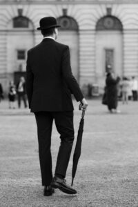 Fliss van Steenbergen: A black and white photograph of a man in a bowler hat with an umbrella