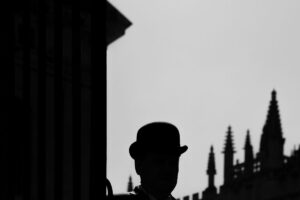 Fliss van Steenbergen: A black and white photograph of an Oxford college porter in the city