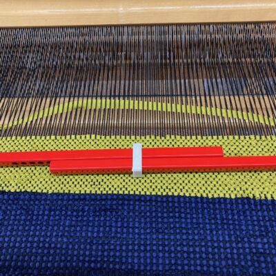 Table mat in 'poppana' - blue, black and lime green, on the loom.