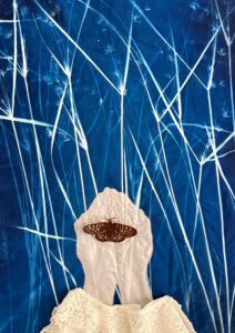 Catherine Rye: Held - A large Cyanotype textile in blue with silhouettes of reeds with embroidered and applique hands cupping a Glanville Fritilliary butterfly