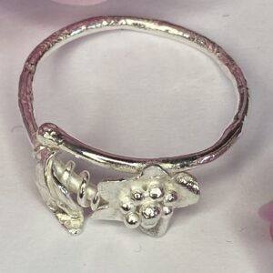 Tsedey Roscoe: Ring - Textured sterling silver flower and leaf on a round wire band