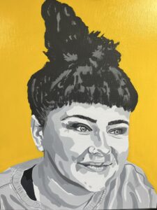 Tania Humphrey: Liala is a real person who once ran a coffee shop in my home town of Banbury. I was inspired to paint her because of her unique style and stunning eyes. Liala is painted in shades of mono on a sunny yellow background. The piece was created using acrylic paint on a 50x40cms canvas. Liala is unframed but ready to hang and available to buy. £300.00.