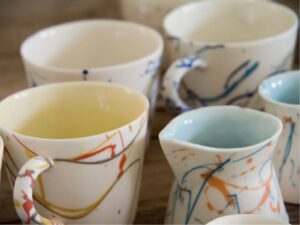 Laura Murphy: Goldfinch, kingfisher and ocean translucent porcelain mugs, jugs, cups and sugar pots