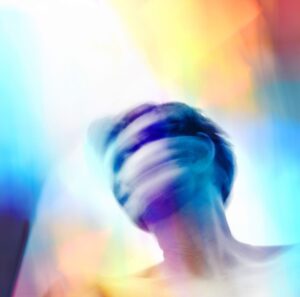 Etain O'Carroll: A blurred image of a head against a colourful background