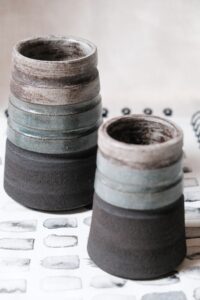 Ariadna Alvarez: Hand-thrown stoneware vase finished in soft blue tones with a raw clay base. A sculptural yet functional form focused on balance and material contrast.